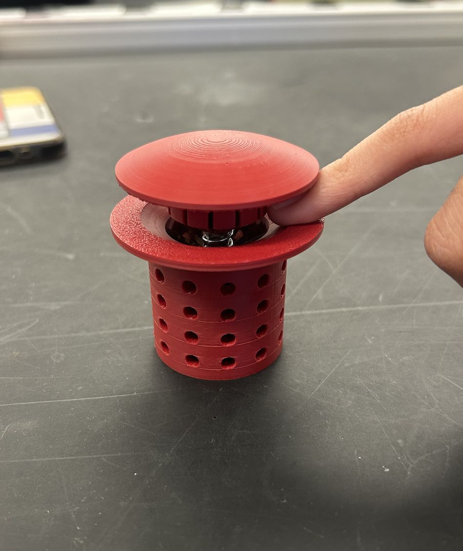 Finger pressing the red prototype cap